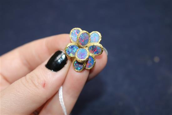 A 1970s textured 18ct gold and eight stone oval black opal set dress ring, size K/L.